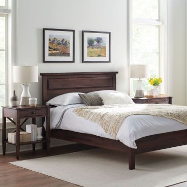 Wooden panel bed frame with a classic headboard, styled in a cozy bedroom setting with matching nightstands and soft lighting.