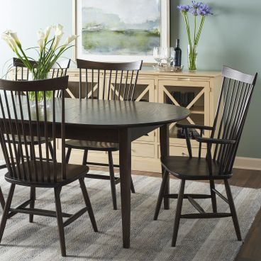 A handcrafted solid wood dining table paired with spindle-back chairs, creating a timeless and elegant dining space.