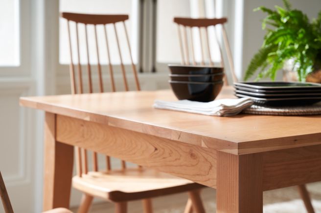 Cherry wood dining table and chairs set, showcasing the intricate joinery and smooth finish.