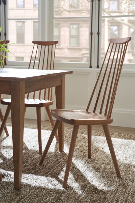 End of a fixed top real wood dining table with solid wood chair