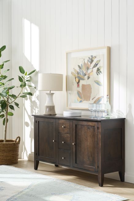 Sunlit corner featuring a sleek wood sideboard and abstract artwork