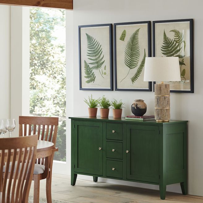 Vibrant Charleston buffet in a striking green finish, complementing the botanical wall art.