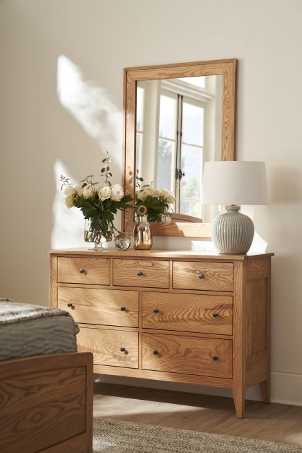 Real Appalachian wood Vineyard 54" Dresser with a mirror, accentuated by natural light and a display of roses and decor.