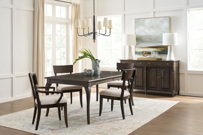 Dining room featuring Coventry Buffet and matching wooden table with upholstered chairs, illuminated by natural light. Elegant wood craftsmanship.