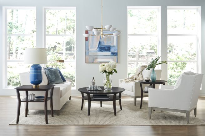 Living room featuring a set of dark wood tables with a polished finish, creating a harmonious balance with the room’s airy ambiance.