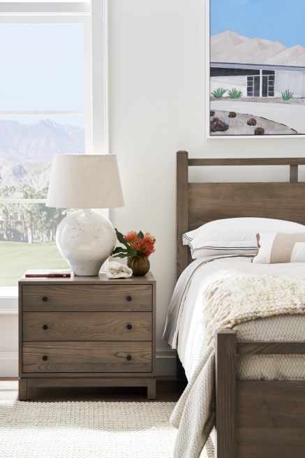 Solid wood bedside table with clean lines and black round knobs.