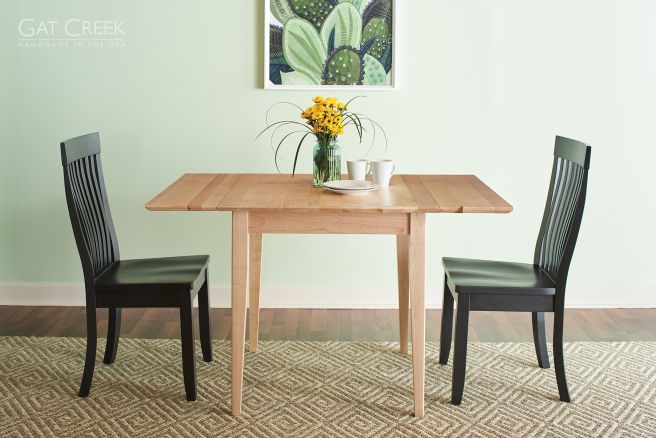 A handcrafted solid wood dining table with an extendable drop-leaf design, paired with high-back slat chairs for a timeless and space-efficient dining experience.