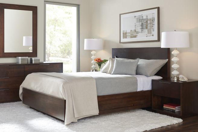 Modern bedroom with a dark wood platform bed, matching nightstand, and dresser, featuring neutral bedding and contemporary decor.
