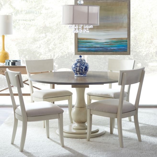 Elegant round dining table featuring a sturdy pedestal base and smooth wooden surface, perfect for cozy gatherings.